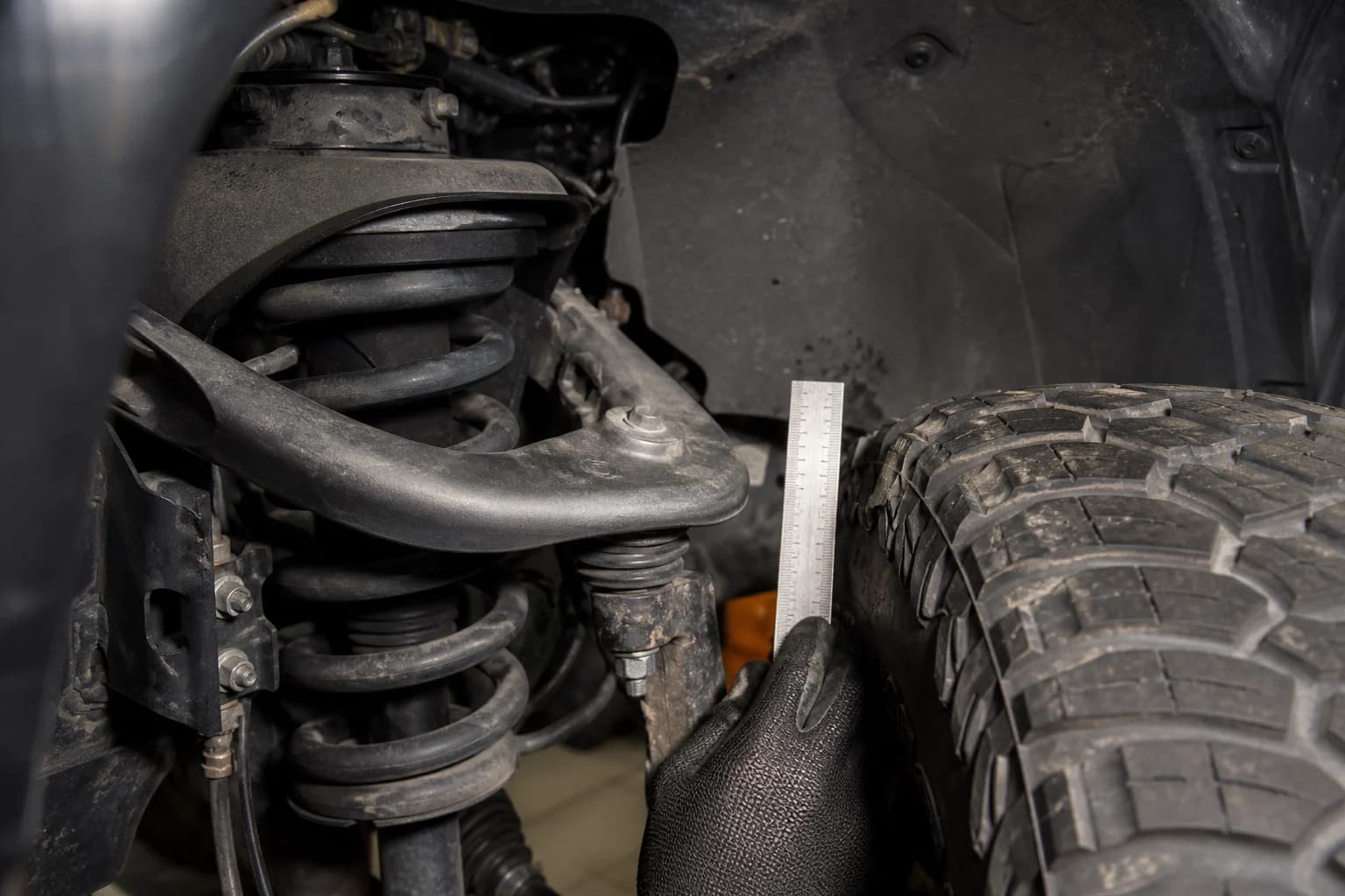 Tire-to-suspension clearance being checked with a ruler